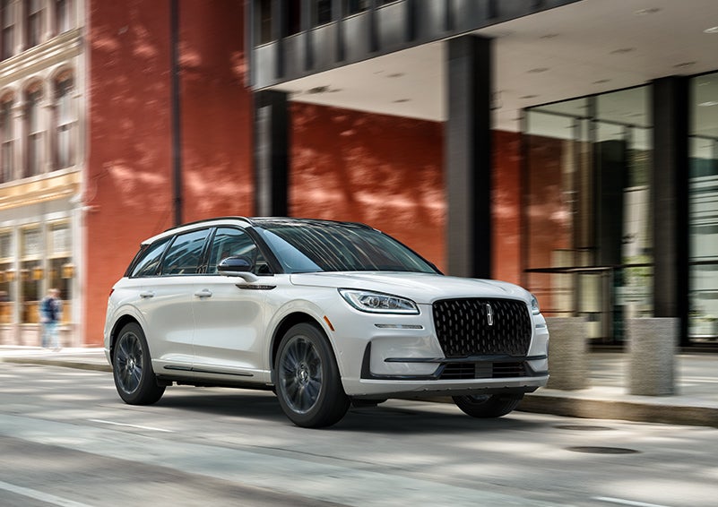 The 2024 Lincoln Corsair® SUV with the Jet Appearance Package and a Pristine White exterior is parked on a city street. | Brinson Lincoln of Athens in Athens TX